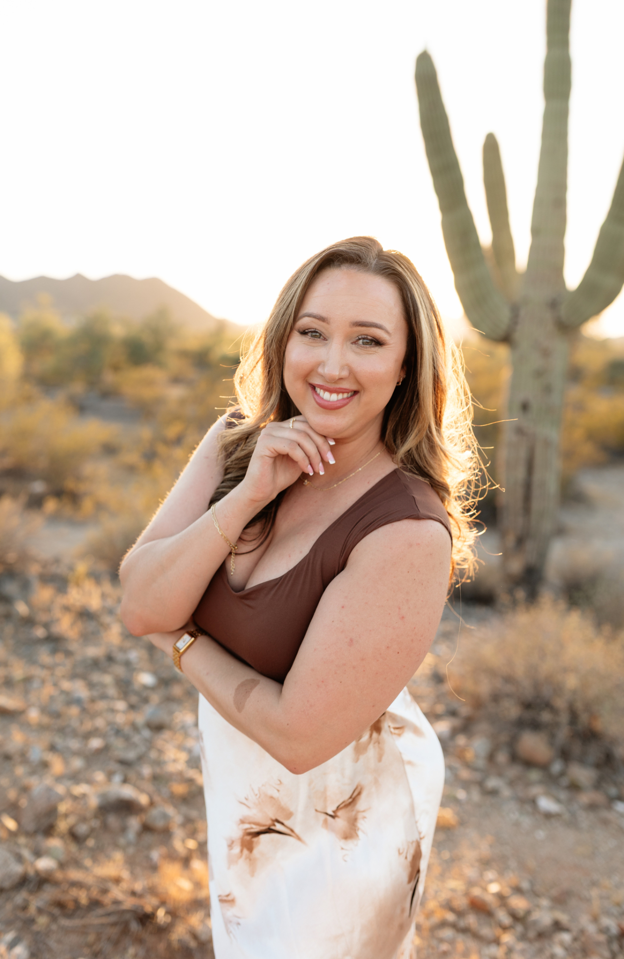 Haylee Duran smiling at golden hour in the Arizona desert near a saguaro cactus